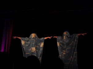 Zwei Menschen in Kostümen auf einer Theaterbühne