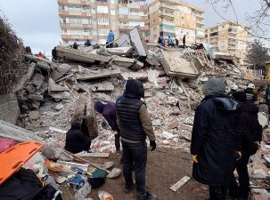 Menschen vor einem zerstörten Haus im türkischen Diyarbakır