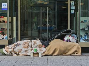 Ein Mann schläft vor einem Geschäft