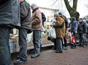 Eine Gruppe Wohnungsloser stehen für eine Suppenküche an