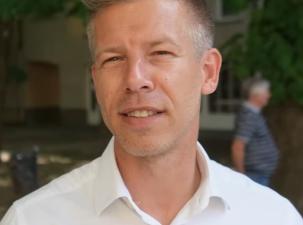 Der ungarische Politiker Péter Magyar wird von Gábor Révész interviewt, nachdem er am 20. Mai 2024 im Vorfeld der Europawahlen in Ungarn bei einer Wahlkampfveranstaltung in Csongrád eine Rede gehalten hat. - Mann mit kurzem, blonden Haar und einem weißen Hemd, steht im Freien vor einem unscharfen Hintergrund.