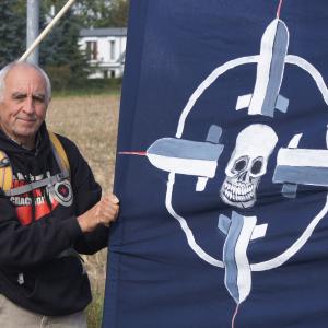 Ein Aktivist bei einer Anti-Nato-Demo neben einem Banner