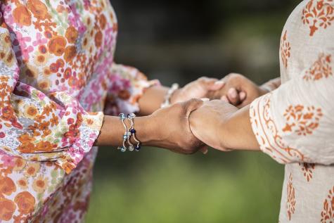 zwei Frauen halten sich an den Händen 