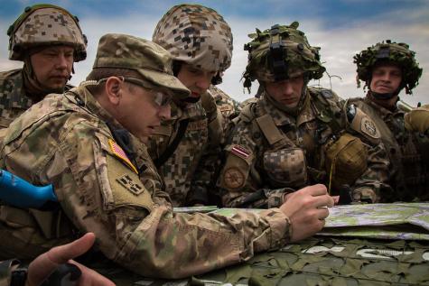 Mehrere NATO-Soldaten bei einer Übungsbesprechung
