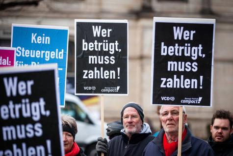 Demo gegen unfaire Besteuerung mit mehreren Schildern