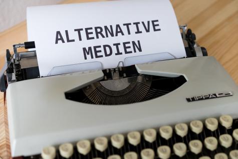 Eine Schreibmaschine mit einem Blatt auf dem Alternative Medien steht