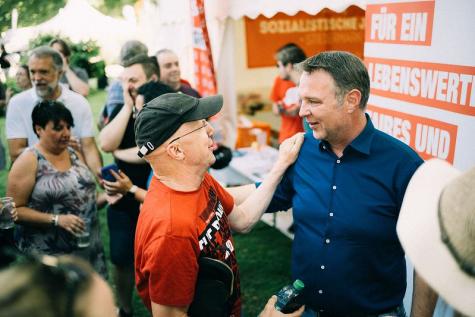 Andreas Babler im Kontakt mit Bewohner bei einer Straßenveranstaltung