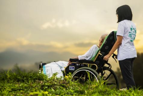 Junge Frau mit Seniorin im Rollstuhl