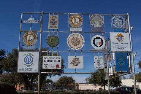 Mehrere Wappen von Serviceclubs auf einer Anschauungstafel